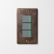 真鍮（燻し） プレート <br>+ NK 片切、3路ガイドランプ（グリーン）スイッチトリプル  グレー